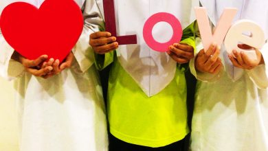 Three girls hold up the letters L O V E and a heart.