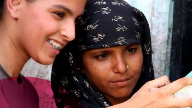 two young girls look at a smart phone.