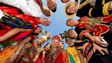 Happy young people in different cultural attire.