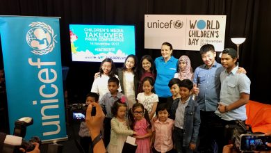 a group of children of different races and backgrounds stand together with UNICEF at the World Children's Day Kidstakeover Media in Malaysia press conference.