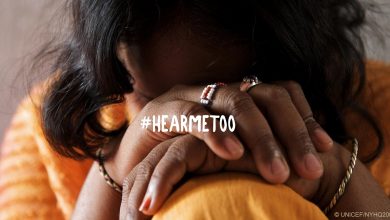 a woman sits with her head covered by her knees. The words "hear me too" are in the middle.