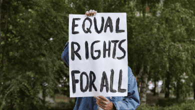 A young person holds up a sign that reads Equal Rights for All.