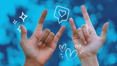 Two people show the sign language for love.